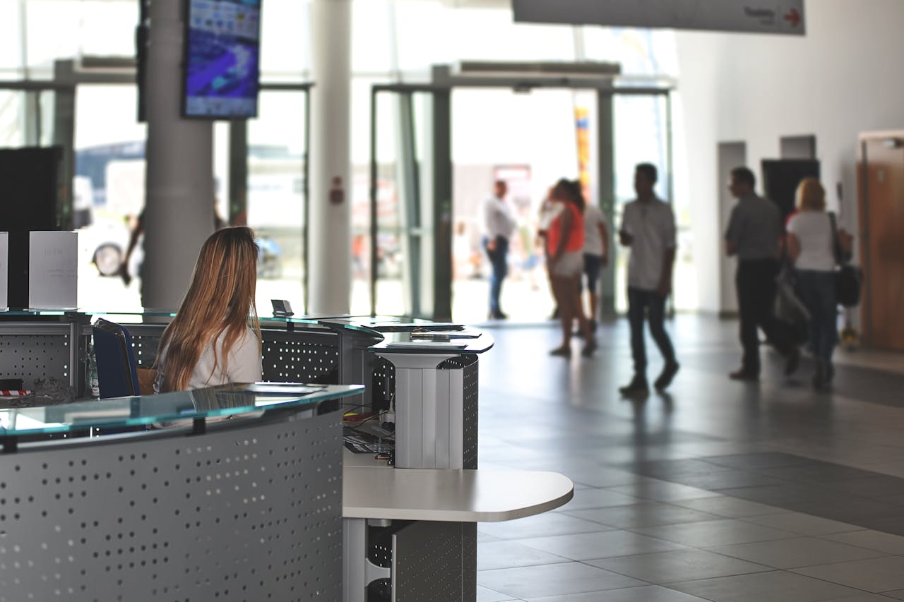 TruNorth reception in a modern lobby with a gray curved desk, glass surface, and staff, highlighting a professional facilities management environment