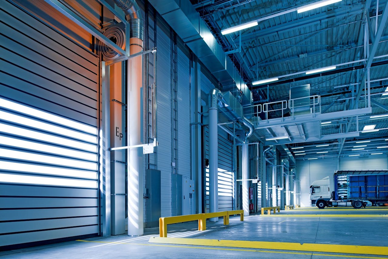 Interior view of a modern warehouse with loading docks and a truck parked inside.