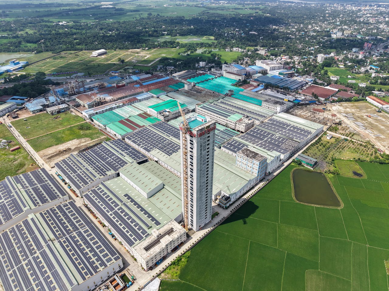 Aerial view of a large industrial complex with multiple buildings and solar panels in a rural landscape.